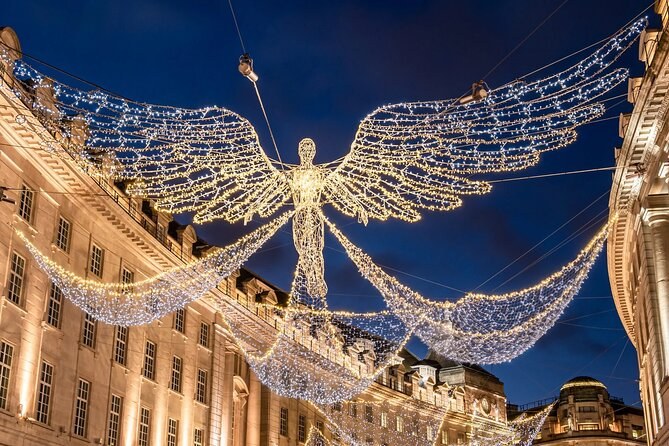 A single angel of lights stretching its wings over lit stone shopfronts at dusk