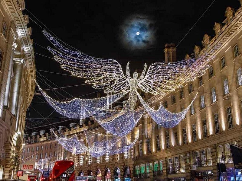 Giant angels of white lights hung across a curving street of stone shopfronts