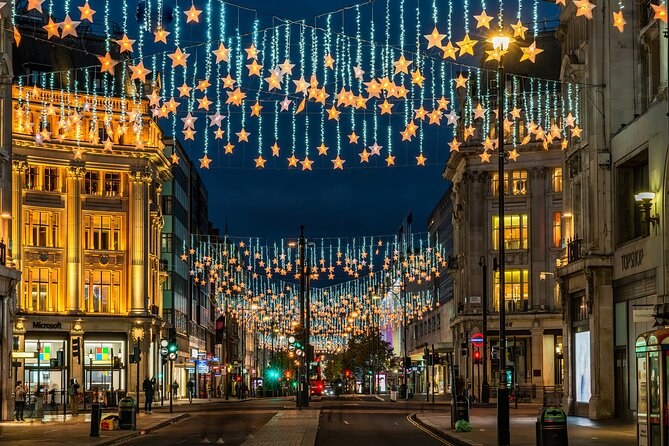 Curtains of gold stars and fairy lights hanging down over a wide street at dusk