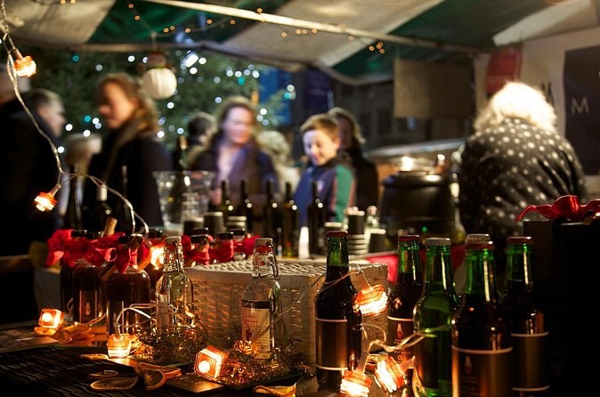 Bottles and lanterns on a market stall selling mulled wine after dark